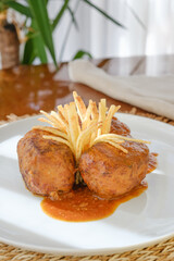 Tuna rolls with crispy potato sticks served with tomato sauce on white plate. Image with copyspace.