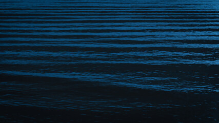 Dark and calm Prussian blue sea ripples forming elegant natural wave lines, perfect for abstract...