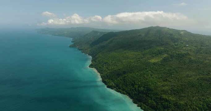 Tropical island with forest and jungle. Blue sea and waves. Samal Island. Davao, Philippines.