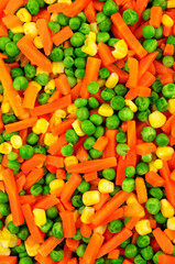 Cooked mixed vegetable background detail including carrots, peas and sweetcorn