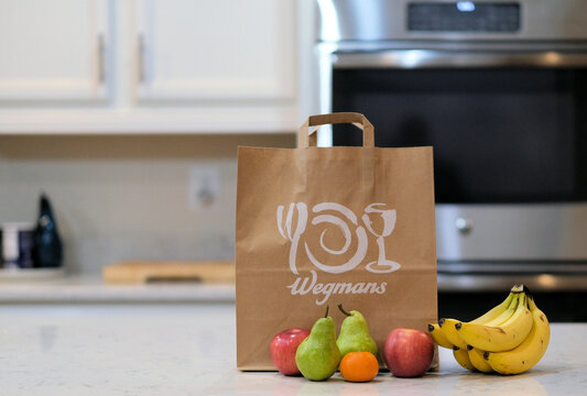 Wegmans Food Markets grocery bag and fruit on a kitchen countertop