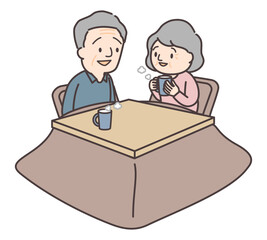 こたつに入りマグカップでコーヒーを飲むシニア夫婦