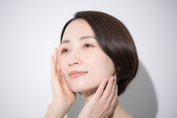 Close-up of a smiling woman with her hand on her cheek Beauty and cosmetics imagery