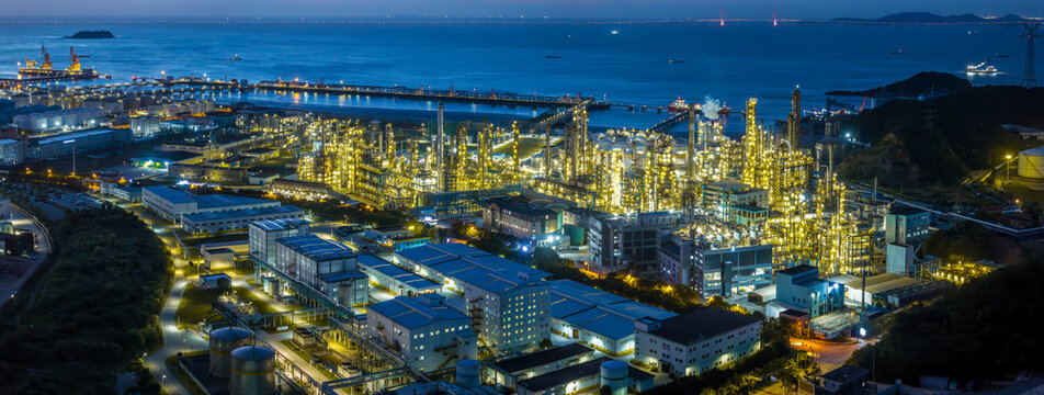 Chemical plant and oil refinery complex at night showing intricate pipelines and structures.