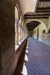 Long stone corridor with arches and sunlight streaming through