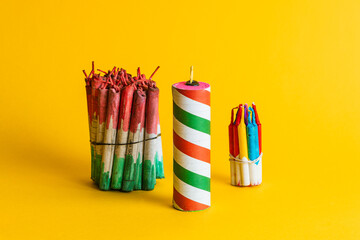 Composition of three bundles of pyrotechnics and a large striped firecracker, highlighting the celebration colors on a yellow background.