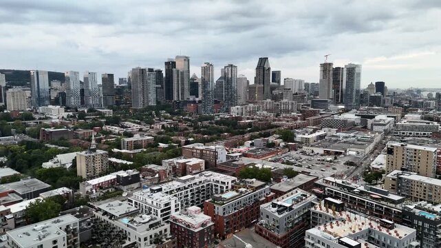 Drone view of single-storey buildings between the Lachine channel and downtown Montreal skyscrapers Quebec, Canada