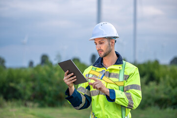 Male man engineer inspection by tablet gesture check control wind power machine out door wind energy factory. technician professional worker check wind power machine turbine field inspection