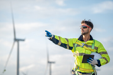 Male man engineer inspection pointing check control wind power machine in out door wind energy factory. Young man technician professional worker check wind power machine for maintenance