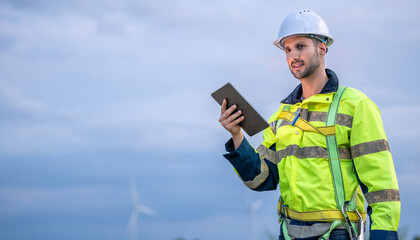 Male man engineer inspection posing check control wind power machine in out door wind energy factory. Young man technician professional worker check wind power machine for maintenance turbine