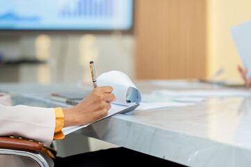 A businesswoman writing notes during a meeting