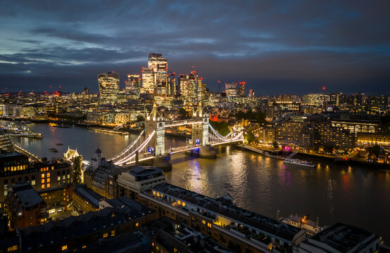 London. UK- October 07. 2025. A high side aerial view of Tower Bridge during blue hour, with the city skyline and skyscrapers behind.