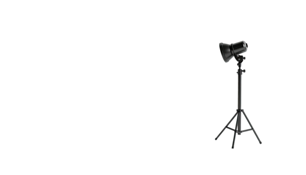 A single studio light on a tripod casts a beam in a black space