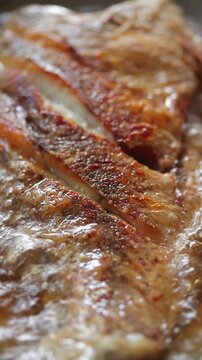 Close-up of crispy white snapper fish texture frying in bubbling oil.