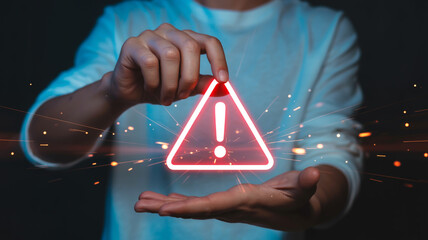 Man holding warning sign with exclamation mark in triangle shape in hand
