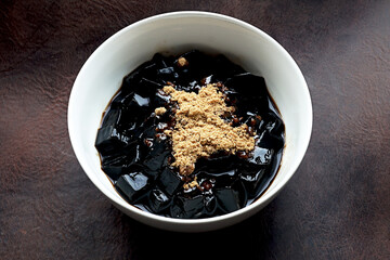 Grass jelly also know as Leaf Jelly or Herbal Jelly cubes with brown sugar refreshing Asian dessert healthy sweet traditional herbal food