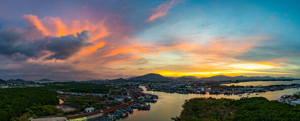 Aerial view of Stunning sunset featuring fishing port in Phuket. The vibrant sky transitions from...