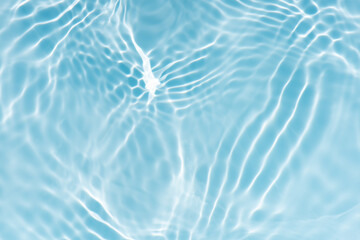 Blue water with ripples on the surface. Defocus blurred transparent blue colored clear calm water surface texture with splashes and bubbles. Water waves with shining pattern texture background.