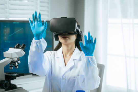 An Asian female scientist wearing a virtual reality headset explores digital simulations in a modern laboratory, surrounded by microscopes, test tubes,merging VR technology with advanced scientific