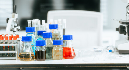 A bright and well-organized laboratory filled with colorful chemical solutions, microscopes, science safety,chemical experiments,safety in a professional biological and chemical research environment