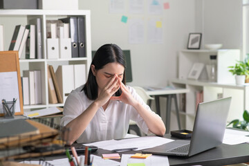 Young Asian Businesswoman looking stressed from work, Young businesswoman working at office feels overworked and burnout