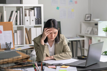 Young Asian Businesswoman looking stressed from work, Young businesswoman working at office feels overworked and burnout