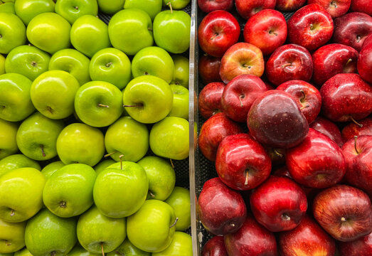 Vibrant and fresh green apples perfectly contrasted with glossy red apples, showcasing healthy produce at a supermarket or grocery store. This view captures healthy eating, choice, diet and nutrition. - Powered by Adobe