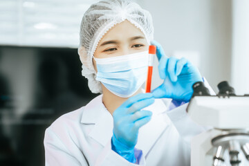 An Asian female scientist carefully analyzes microscopic samples and chemical solutions in a modern laboratory, conducting biology, microbiology, pharmaceutical, and medical research with precision