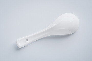 The backside of a ceramic spoon used for soups, isolated on white.