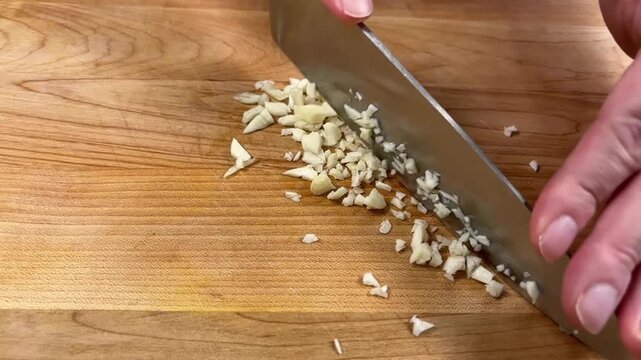 Slow Motion Video of Mincing Fresh Garlic with Kitchen Knife