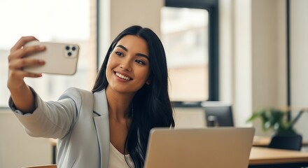 Woman taking selfie at her desk