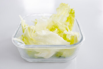 iceberg lettuce in glass lunchbox on kitchen bench healthy food concept