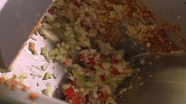 Chopped apples and fruit pieces inside an industrial crusher during juice production. The raw mix is processed before pressing in a modern food manufacturing facility.