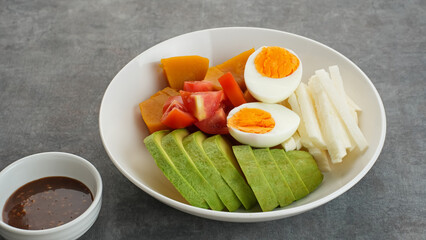 Healthy Salad Bowl, mix vegetables pumpkin, jicama, tomatoes, avocado and egg with sesame sauce.