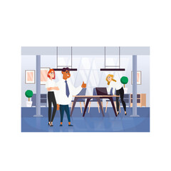 Diverse team of professionals in a modern office space collaborating around a sleek table with laptops and plants providing a bright and airy atmosphere during daylight hours