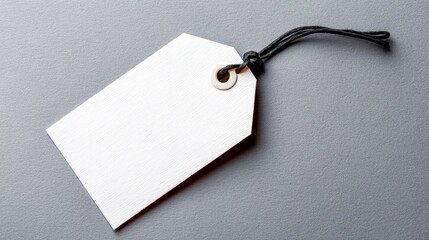 Clean white tag with black string on a gray background perfect for labeling gift packaging and identification.