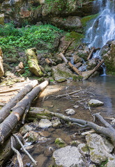 waterfall on a mountain river, natural flow of water from rocky ground, state of nature