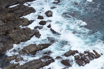 Background of turquoise sea water and white foam of wave with rock on seaside, copy space