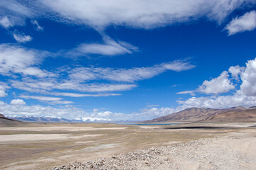 The vast arid land with blue sky and white clouds
