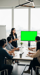 Young Entrepreneur Presenting to Team with Green Screen Display