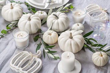 Place settings with white pumpkins for Thanksgiving