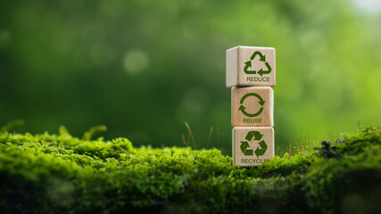 Recycle symbol on wooden blocks in green nature background. Eco concept for recycling, sustainable...