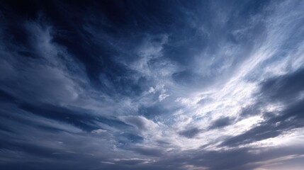 A dramatic sky filled with swirling clouds, showcasing a mixture of dark and light shades, creating an atmospheric and captivating scene.