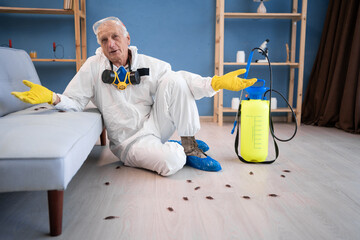 Pest control exterminator elderly man in protective suit sitting on floor near cockroaches says I...