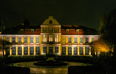 Beautiful building of the ancient Oliwa cathedral and public park at night 