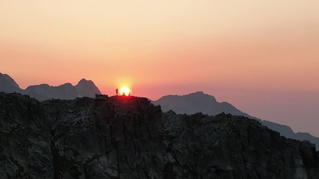 Dos personas en cima de una monta&ntilde;a con sol de fondo