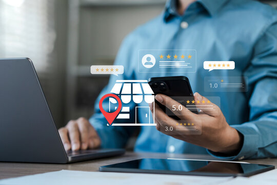 SEO, Businessman using smartphone and laptop with digital store icon, location pin, and customer review stars. Concept for local business marketing, online rating, and brand reputation management.