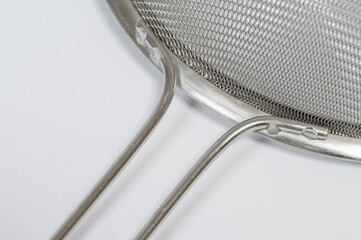 Close-up detail of the mesh and handle of a stainless steel strainer