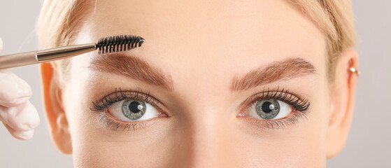 Young woman undergoing eyebrow correction procedure, closeup