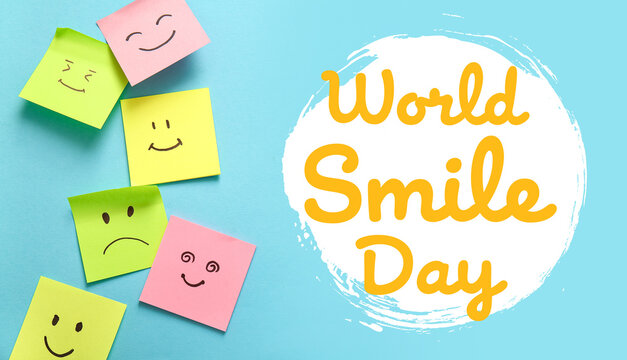 Sticky papers with drawn happy and sad faces on blue background. World Smile Day